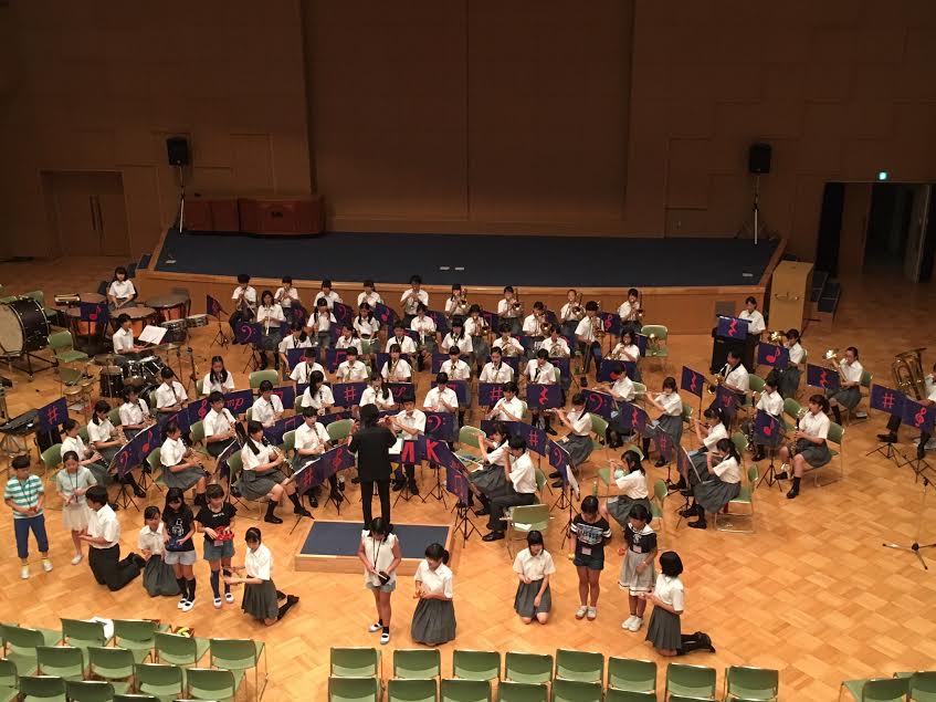 吹奏楽部主催講座で演奏する小学生受講者と吹奏楽部。